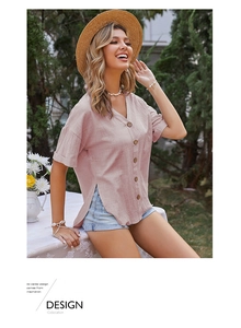 Dettaglio della camicia in lino rosa chiaro con scollo a V e bottoni in legno naturale