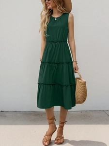 Dettaglio di un abito estivo a balze verde scuro con vita elastica e design senza maniche