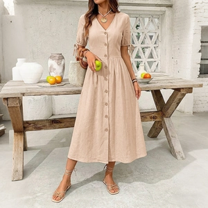 Detail of V-neck beige cotton linen dress with wood buttons and lace-up sleeves for summer