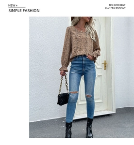 Detailed street style view of leopard print long sleeve top with blue ripped skinny jeans