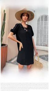 Detail of black summer cotton dress with V-neck lace-up design and puff sleeves
