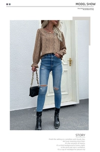 Close-up of leopard print chiffon blouse with ruffled cuffs and ripped skinny jeans outfit