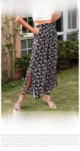Détail du pantalon évasé noir à fleurs taille haute avec fente latérale élégante