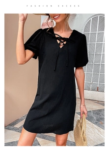 Detail of black V-neck cotton linen dress featuring lace-up design and lantern sleeves