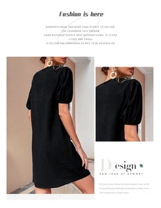 Detail view of the black cotton linen dress showing the pleated sleeve and fabric texture