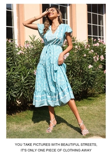 Detail of light blue bohemian floral dress with V-neck button and tiered ruffle skirt