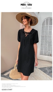 Detail of V-neckline with self-tie bow on a black summer cotton linen dress