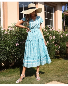 Close-up of light blue boho print dress with V-neck and butterfly sleeves in garden setting