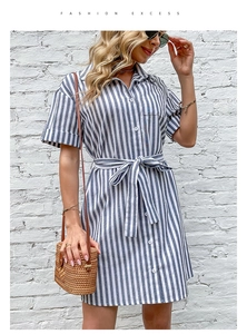 Detail of blue striped shirt dress with a waist tie, lapel collar, and white buttons