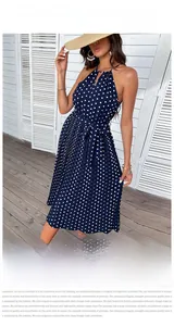 Dettaglio dell'abito blu scuro a pois con gonna a pieghe e cintura in vita