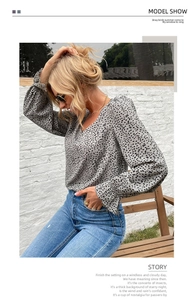 Detail shot of grey leopard print blouse with elastic cuffs and denim jeans