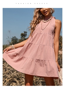 Details eines rosa gestuften Sommerkleids mit Rüschen am hohen Ausschnitt und ärmellosem Design