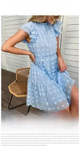Detail of light blue chiffon summer dress featuring white pom pom jacquard texture