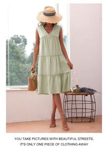 Detail of light green sleeveless V-neck tiered cotton linen summer dress on model