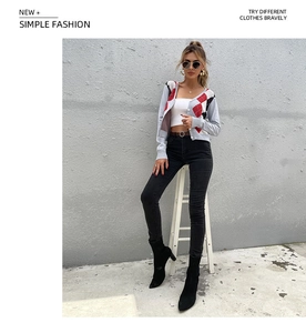 Full body shot of a woman wearing a grey argyle V-neck cardigan with white crop top and pants