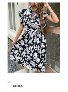 Detail of floral printed summer dress featuring ruffled sleeves and waist tie design