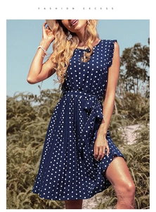 Detailed view of polka dot navy dress with waist tie and ruffle sleeve accents