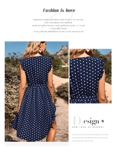 Detail of navy blue polka dot dress with pleated fabric and ruffled shoulder design