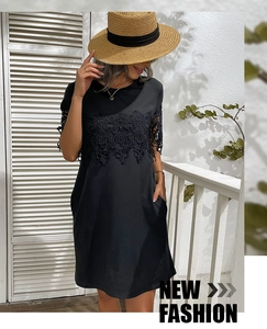 Detail of black short sleeve dress featuring intricate lace splicing and round neckline