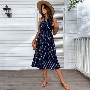 Abito a pois blu navy con scollo all'americana e cappello di paglia per spiaggia estiva