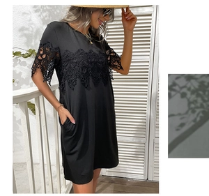 Detailed view of black short sleeve dress with delicate lace patchwork and side pockets