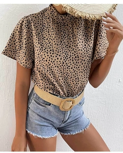 Detail of leopard print high-neck blouse paired with denim shorts and straw hat