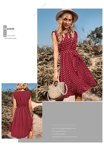 Detail view of burgundy polka dot summer dress with waist tie and flowy pleated skirt