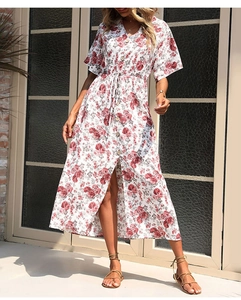Detail of V-neck floral dress showing front slit and red flower print on white fabric