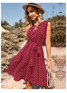Detailed view of dark red polka dot dress showing pleated chiffon and ruffled shoulder trim