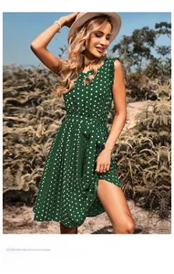 Detail of dark green polka dot sleeveless pleated dress with waist tie and ruffle shoulder