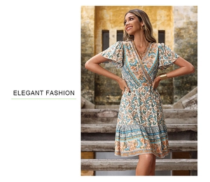 Detail of bohemian wrap dress featuring V-neckline and ruffled cap sleeves in orange print
