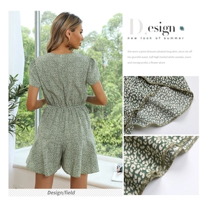 Detail view of the green floral romper showing bubble sleeves and waistline tailoring
