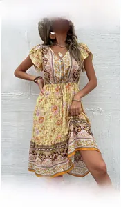 Détail d'une robe bohème jaune à col en V avec imprimé floral et manches à volants