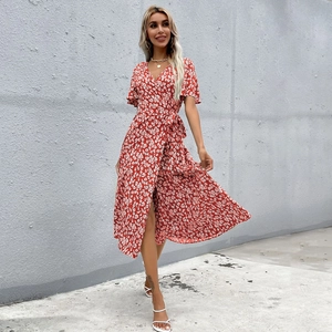 Détail de robe portefeuille rouge à fleurs avec col en V et manches à volants
