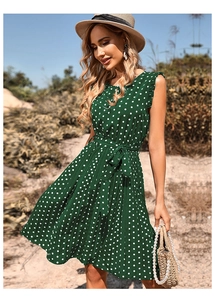 Close-up detail of dark green polka dot pleated dress with round neck and chiffon ruffles