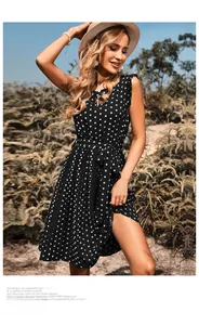 Detail of polka dot dress featuring a pleated skirt, waist belt, and ruffled sleeves