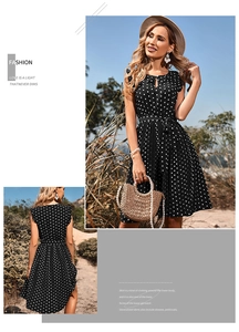 Detail view showing black polka dot pleated dress with waist tie and round neck