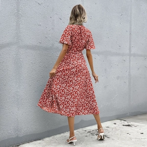 Détail d'une robe midi rouge à fleurs avec dos en V croisé et taille cintrée élégante