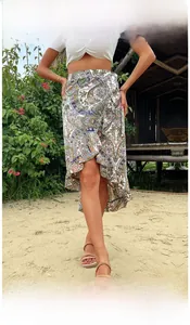 Detail of bohemian paisley print wrap skirt with ruffled hemline in outdoor tropical beach