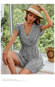 Detail view of v-neck floral romper with ruffles and summer accessories in outdoor setting