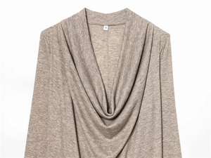 Détail d'un haut en maille couleur avoine avec col drapé et étiquette de taille S blanc