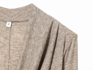 Détail de la texture en maille marron clair douce et de l'étiquette de taille S
