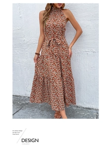 Détail du décolleté dos nu plissé et du motif floral orange sur une robe d'été légère
