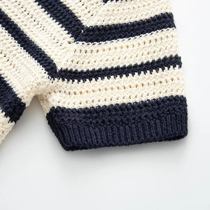 Dettaglio della trama a maglia a righe blu e crema con polsini a coste dell'abito