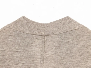 Détail du col côtelé et de la texture en maille fine du t-shirt beige à manches longues