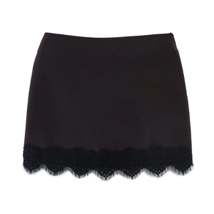 Détail d'une mini-jupe noire avec bordure en dentelle délicate et finition de tissu lisse