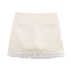 Vue détaillée de l'ourlet de la jupe abricot avec broderie de dentelle florale blanche