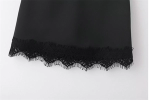 Détail d'une jupe courte noire avec une finition en dentelle de cils délicate sur l'ourlet