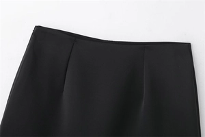 Détail d'une jupe noire à taille haute avec coupe lisse et fermeture éclair invisible