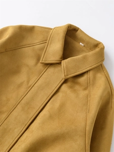 Detailed close-up of mustard yellow suede texture and shoulder stitching on a flight jacket